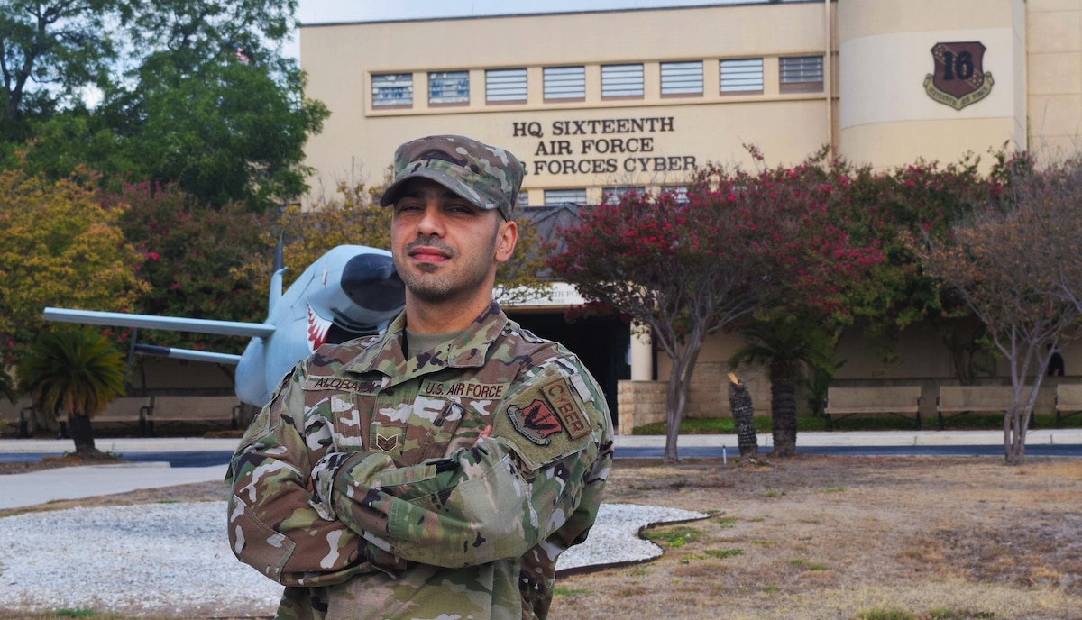 A photo of an Airman posing in front of 16th Air Force headquarters building.