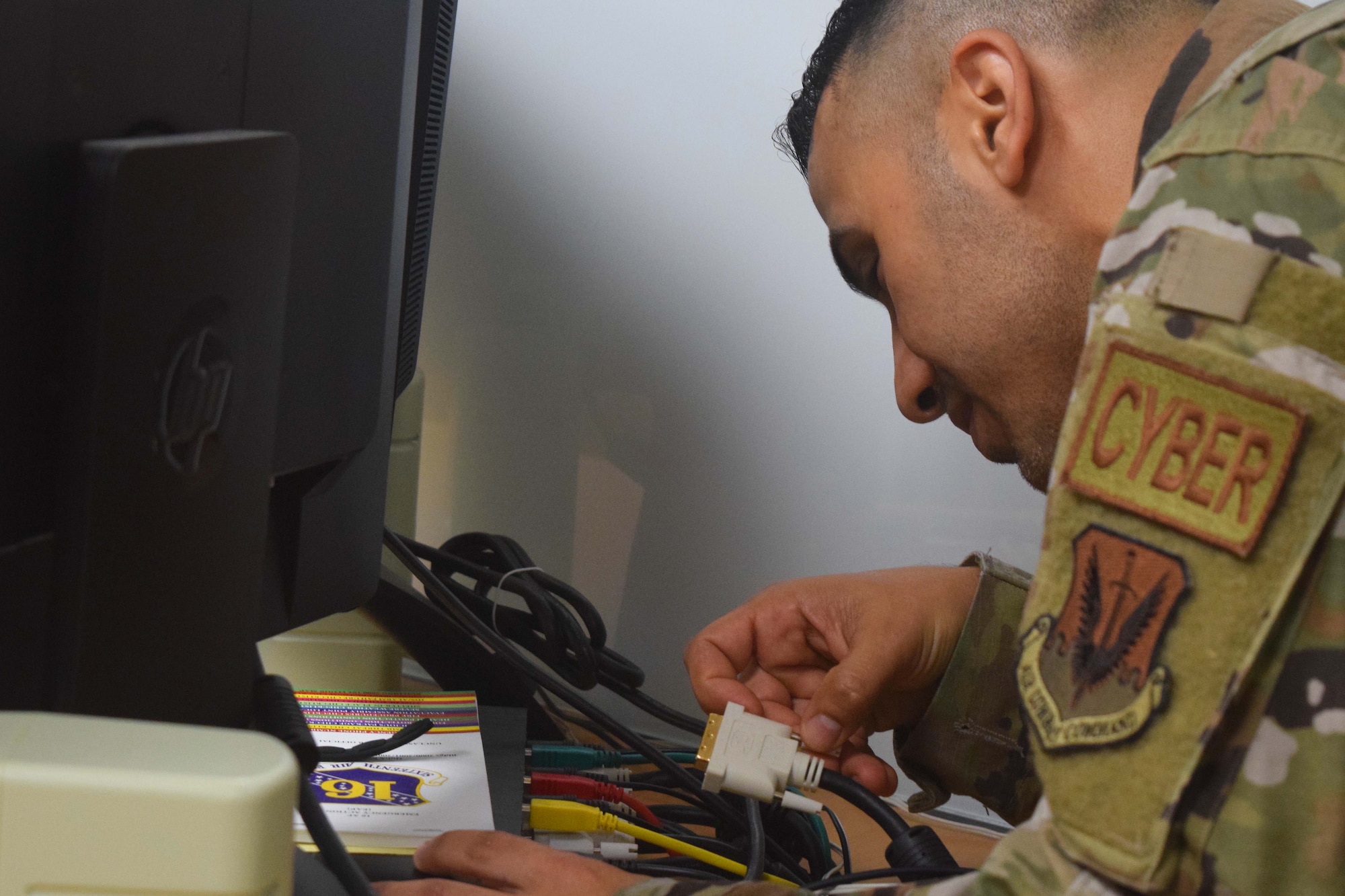 A photo of an Airman connecting communication equipment.