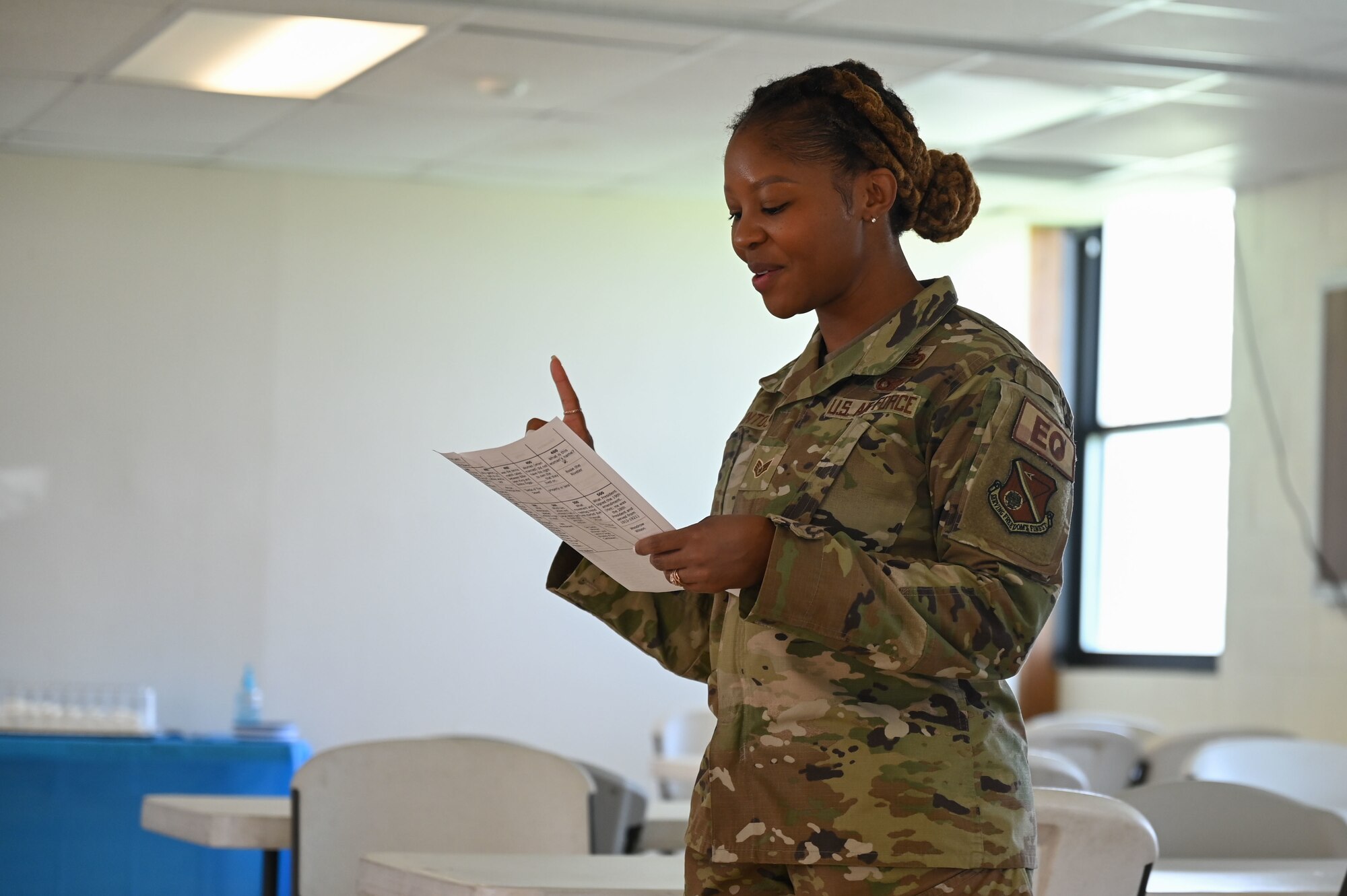 A woman speaks while holding paper.