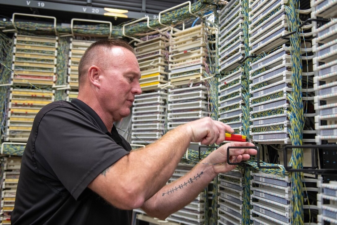 Chris Gleason, 28th Communications Squadron manager, makes a circuit connection at Ellsworth Air Force Base, S.D., Aug. 2, 2022.