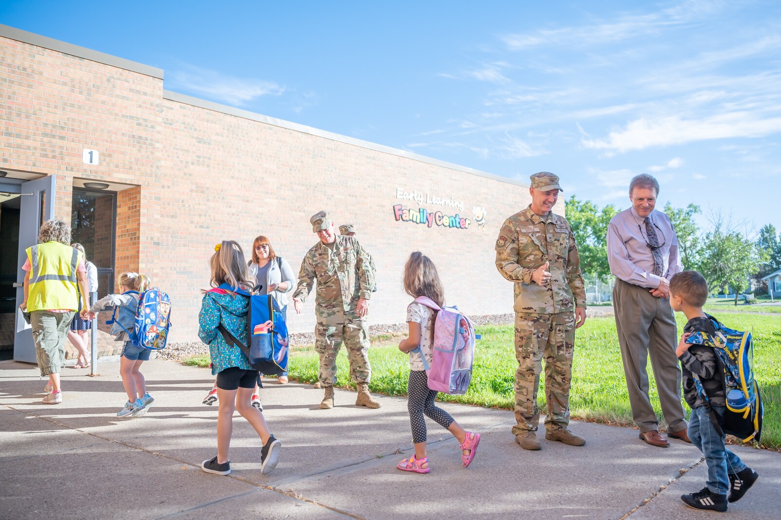 Tom Moore, Great Falls Public Schools superintendent, far right, and Col. Barry Little, 341st Missile Wing commander, right, greet students during the first day of transitional kindergarten at the GFPS Early Learning Family Center Aug. 29, 2022, in Great Falls Mont.