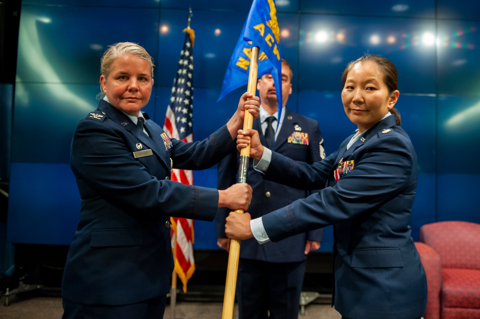 Col. Catherine A. Gambold, Air and Cyberspace Intelligence Group commander, passes the guidon to Lt. Col. Melissa H. Keown, outbound Information Warfare Analysis Squadron commander, during the squadron’s change of command ceremony June 29 at the Air Force Institute of Technology, Wright-Patterson Air Force Base, Ohio. The change of command ceremony is one of the most significant of all military ceremonies. All authority and responsibility for command are vested in the hands of the commander, a chain unbroken to the Commander-in-Chief, the President of the United States. No unit shall ever, even for a brief moment, be without a commander. (U.S. Air Force photo by Senior Airman Kristof J. Rixmann)