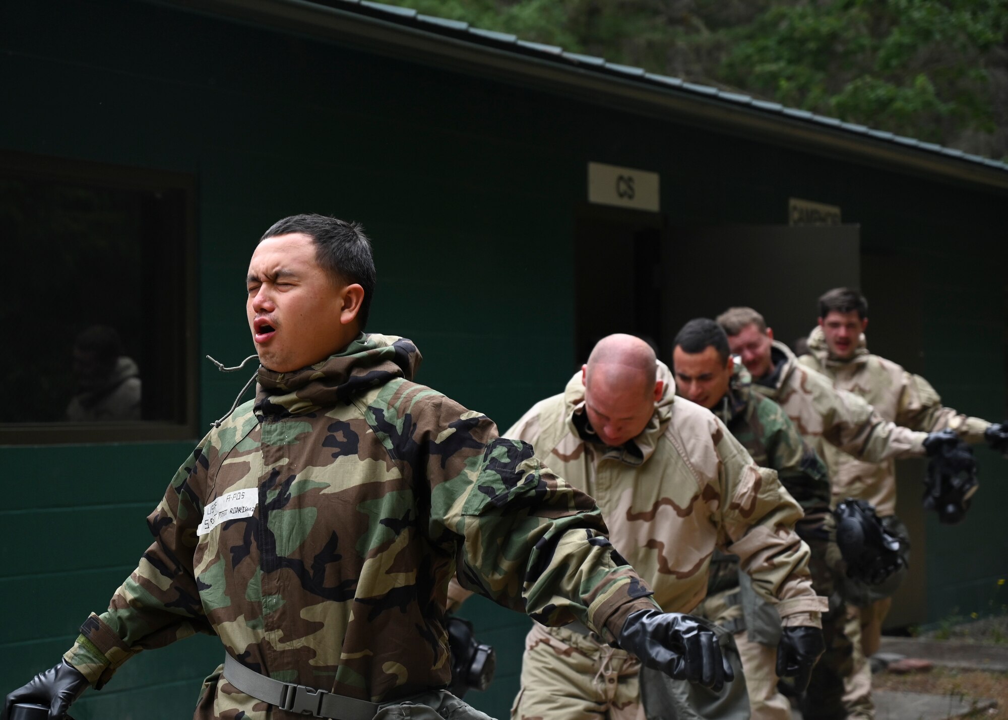 U.S. Air Force Airmen with the 627th Civil Engineer Squadron exit the gas chamber during a joint exercise at Joint Base Lewis-McChord, Washington, Aug. 26, 2022. The 627th CES partnered with the 349th Chemical Company for a chemical, biological, radiological, and nuclear exercise to ensure Airmen are proficient in using a gas mask to prepare them for a biological or chemical attack. (U.S. Air Force photo by Senior Airman Callie Norton)
