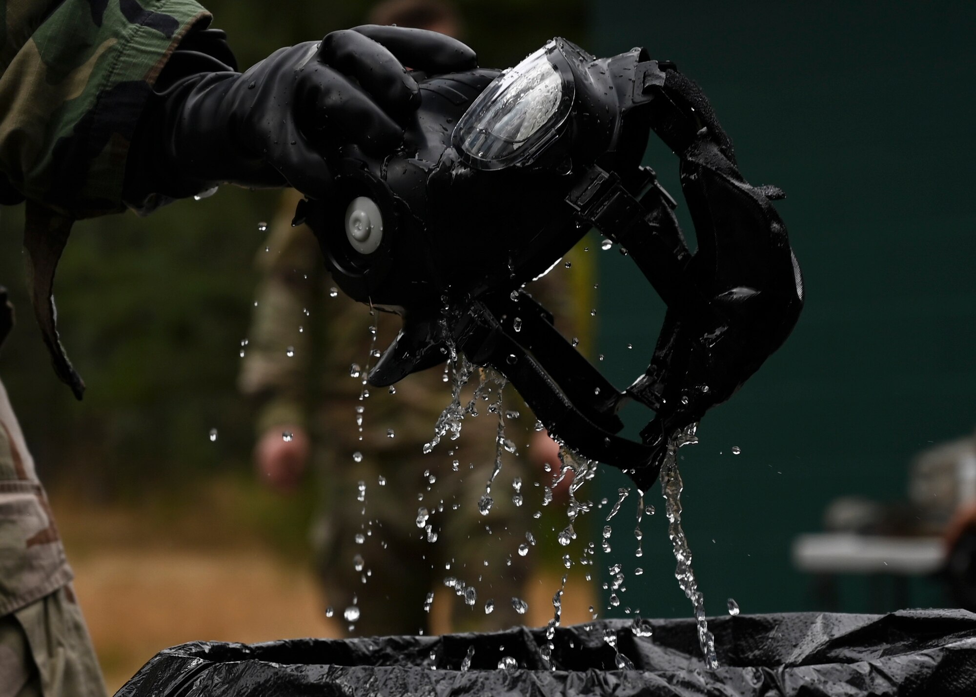 A U.S. Air Force Airman with the 627th Civil Engineer Squadron sanitizes his gas mask during a joint exercise at Joint Base Lewis-McChord, Washington, Aug. 26, 2022. The 627th CES partnered with the 349th Chemical Company for a chemical, biological, radiological, and nuclear exercise to ensure Airmen are proficient in using a gas mask to prepare them for a biological or chemical attack. (U.S. Air Force photo by Senior Airman Callie Norton)