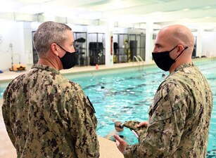 GREAT LAKES, Ill. (Aug. 24, 2022) Master Chief Explosive Ordnance Disposal Technician Robert Wandel, right, assigned to the Center for Explosive Ordnance Disposal and Diving (CEODD), discusses training with Rear Adm. Pete Garvin, commander, Naval Education and Training Command (NETC), during a visit to CEODD in Great Lakes, Illinois, Aug. 24, 2022. The learning site runs two courses of instruction for explosive ordnance disposal (EOD), Navy diver (ND) and diving medical technician (DMT) candidates.  The 18-day preparatory course is designed to prepare Sailors for EOD and ND “A” schools by providing training and mentoring in entry-level aquatic adaptability and physical and mental conditioning.  The 22-day Assessment and Selection Course is designed to prepare the most qualified EOD and ND candidates for a career in the Naval special operations community.  As the owner of the Force Development pillar within MyNavy HR, Garvin leads the NETC mission to recruit, train and deliver those who serve the nation, taking them from “street to fleet” by transforming civilians into highly skilled, operational and combat ready warfighters. (U.S. Navy photo by Matt Mogle)