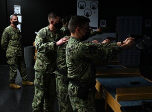 GREAT LAKES, Ill. (Aug. 24, 2022) Rear Adm. Pete Garvin, commander, Naval Education and Training Command, left, observes as Instructor Gunner's Mate 1st Class Nathan A. Fontaine helps to correct a student’s fundamentals during a small arms training evolution on the MILO simulator at Gunner's Mate "A" School, Surface Combat Systems Training Command Great Lakes, Aug. 24, 2022. During a three-day visit, Garvin toured facilities and engaged with Sailors at NETC schools for surface warfare, combat systems and advanced swim preparation, including observing the latest in modernized training methods for hands-on and virtual reality simulations.  As the owner of the Force Development pillar within MyNavy HR, Garvin leads the NETC mission to recruit, train and deliver those who serve the nation, taking them from “street to fleet” by transforming civilians into highly skilled, operational and combat ready warfighters. (U.S. Navy photo by Matt Mogle)