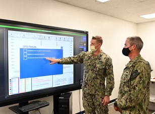 GREAT LAKES, Ill. (Aug. 24, 2022) Gas Turbine Systems Technician (Mechanical) 1st Class Jeremy Pierce, left, assigned to Surface Warfare Engineering School Command, discusses a Multipurpose Reconfigurable Training System 3D® (MRTS 3D®) simulator with Rear Adm. Pete Garvin, commander, Naval Education and Training Command (NETC), at Gas Turbine Systems Technician-Mechanical (GSM) “C” School in Great Lakes, Illinois, Aug. 24, 2022.  The Rolls Royce AG9140RF Full Authority Digital Control MRTS 3D® fault troubleshooter gives Sailors a virtual training delivery method where troubleshooting and corrective maintenance are accomplished without damaging real equipment. As the owner of the Force Development pillar within MyNavy HR, Garvin leads the NETC mission to recruit, train and deliver those who serve the nation, taking them from “street to fleet” by transforming civilians into highly skilled, operational and combat ready warfighters. (U.S. Navy photo by Matt Mogle)