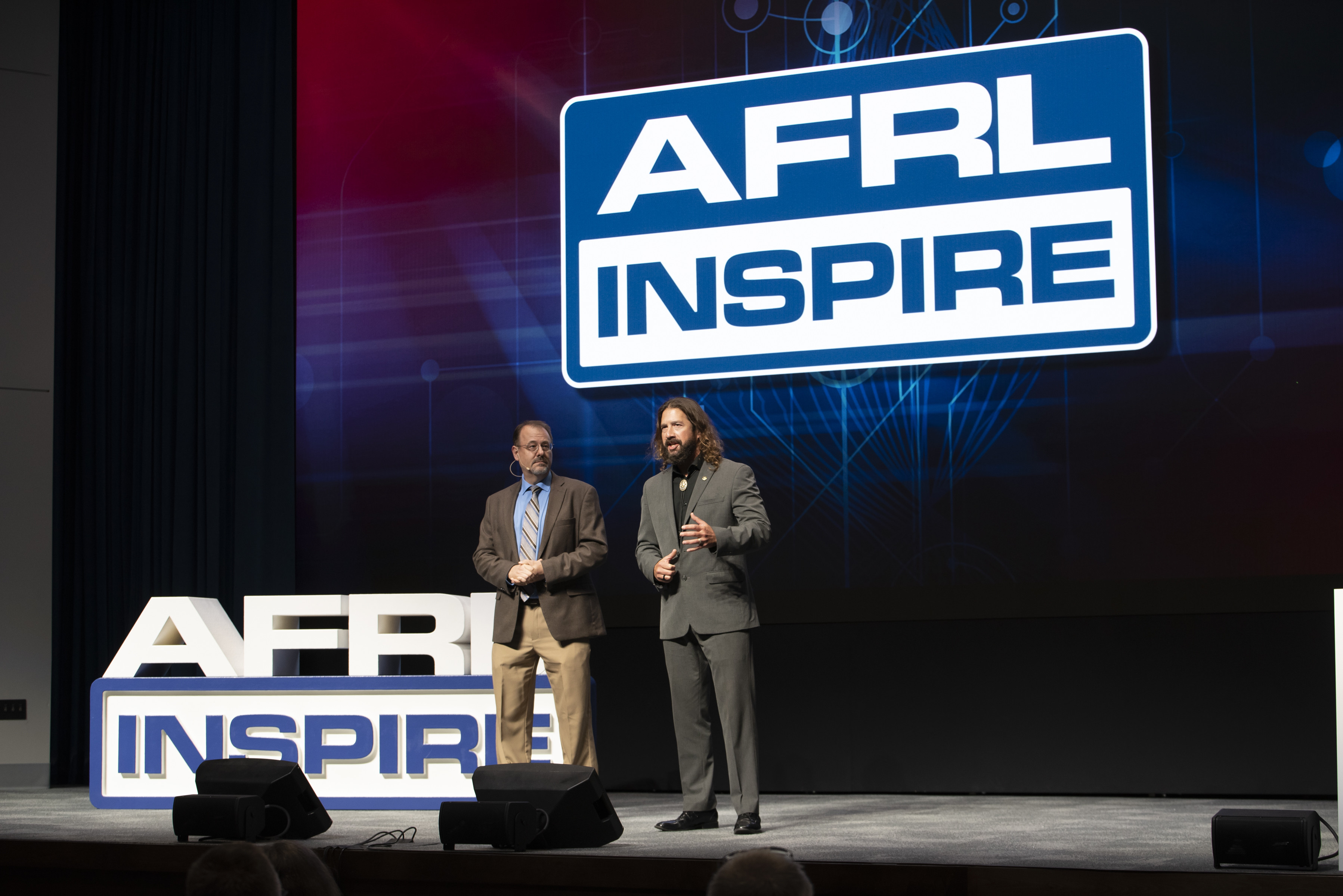 Air Force Research Laboratory historians Jeff Duford, left, and Dr. Darren Raspa, right, host AFRL Inspire in celebration of the U.S. Air Force's 75th anniversary. AFRL held this special TEDx-style event at the Air Force Institute of Technology's Kenney Hall at Wright-Patterson Air Force Base, Aug. 23, 2022. (U.S. Air Force photo / Rick Eldridge)