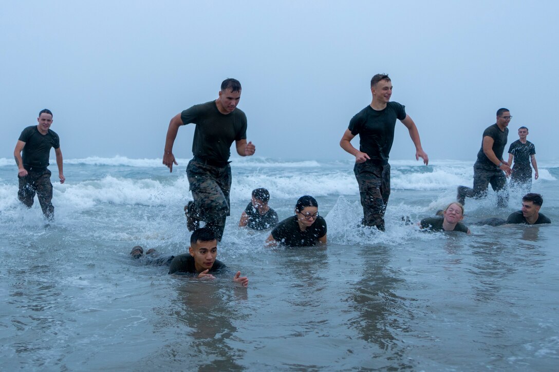 U.S. Marines with Headquarters and Support Battalion's Corporals Course 4-22, buddy rush during a physical training exercise at Del Mar Beach on Marine Corps Base Camp Pendleton, California, Aug. 16, 2022. Corporals Course provides Marines with the skills and knowledge necessary to become successful small-unit leaders. (U.S. Marine Corps photo by Lance Cpl. Espitia)