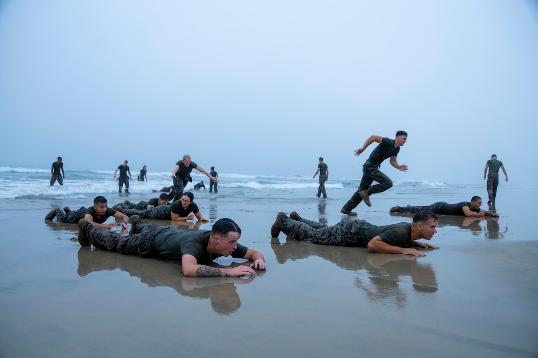 U.S. Marines with Headquarters and Support Battalion's Corporals Course 4-22, buddy rush during a physical training exercise at Del Mar Beach on Marine Corps Base Camp Pendleton, California, Aug. 16, 2022. Corporals Course provides Marines with the skills and knowledge necessary to become successful small-unit leaders. (U.S. Marine Corps photo by Lance Cpl. Espitia)