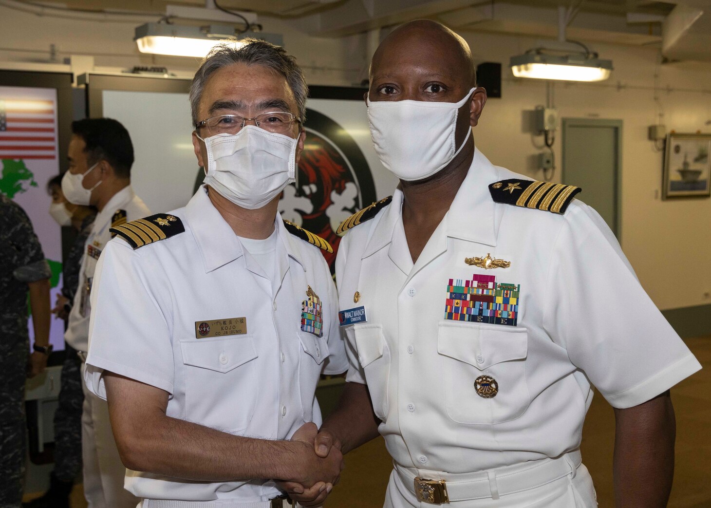 Capt. Walter Mainor, commander, Task Force 71, poses for a photo with Japan Maritime Self-Defense Force (JMSDF) Capt. Hisanori Kojo, commanding officer of JMSDF helicopter destroyer JS Izumo (DDH 183) during the opening ceremony for Pacific Vanguard (PV) 22-1 held aboard Izumo pierside at Naval Base Guam, Aug. 25. PV 22-1 is an exercise with a focus on interoperability and the advanced training and integration of allied maritime forces.