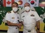 Cmdr. Joseph McGettigan, commanding officer of Arleigh Burke-class guided-missile destroyer USS Higgins (DDG 76), poses for a photo with Japan Maritime Self-Defense Force (JMSDF) Capt. Hisanori Kojo, commanding officer of JMSDF helicopter destroyer JS Izumo (DDH 183) during the opening ceremony for Pacific Vanguard (PV) 22-1 held aboard Izumo pierside at Naval Base Guam, Aug. 25. PV 22-1 is an exercise with a focus on interoperability and the advanced training and integration of allied maritime forces.