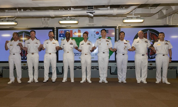 Participants from the Royal Australian Navy, Royal Canadian Navy, Japan Maritime Self-Defense Force (JMSDF), Republic of Korea Navy, and U.S. Navy pose for a group photo during the opening ceremony for Pacific Vanguard (PV) 22-1 held aboard JMSDF helicopter destroyer JS Izumo (DDH 183) pierside at Naval Base Guam, Aug. 25. PV 22-1 is an exercise with a focus on interoperability and the advanced training and integration of allied maritime forces.