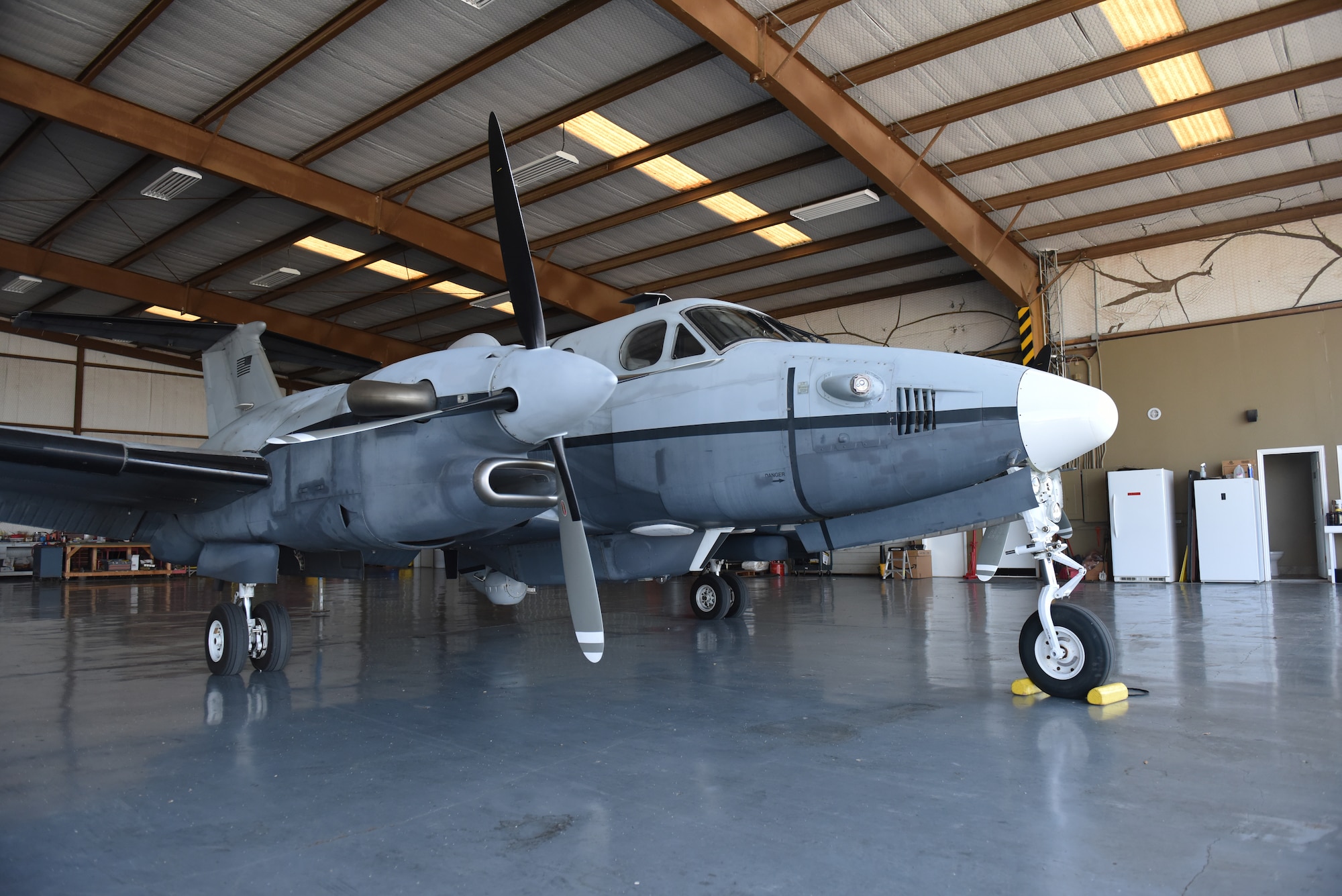 An MC-12W assigned to the 137th Special Operations Wing, Oklahoma National Guard, rests in a hangar at San Angelo Regional Airport-Mathis Field, Texas, Aug. 24, 2022. The MC-12W is a twin-engine turbo prop aircraft used for intelligence, surveillance and reconnaissance missions in support of ground forces around the world. (U.S. Air Force photo by Airman 1st Class Zachary Heimbuch)