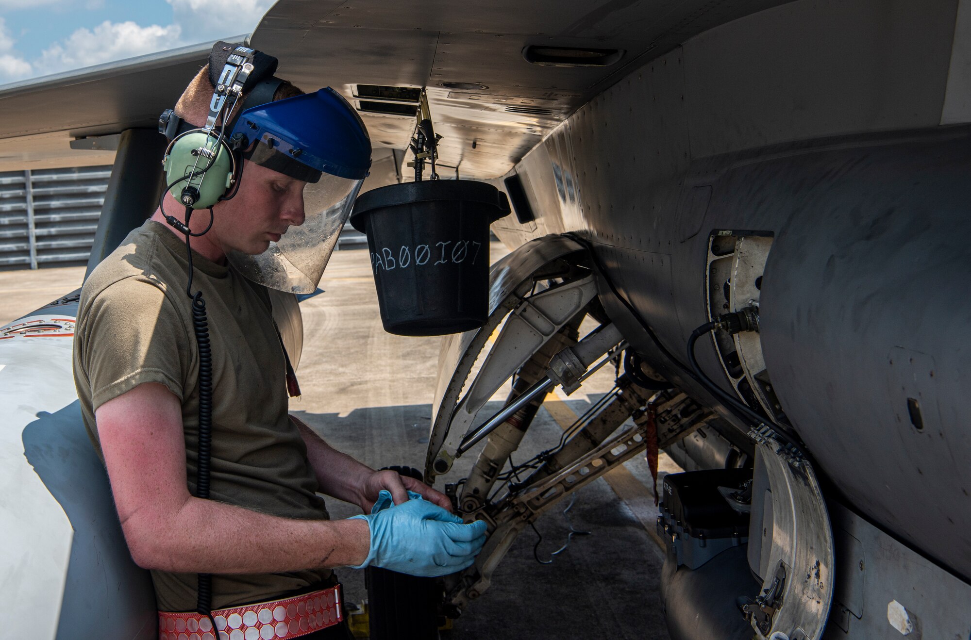 Senior Airman Sean Wehner, 36th Fighter Generation Squadron aerospace propulsion journeyman, puts on gloves before draining hydraulic fluid from an A-10C Thunderbolt II during a training sortie at Gwangju Air Base, Republic of Korea, Aug. 18, 2022.