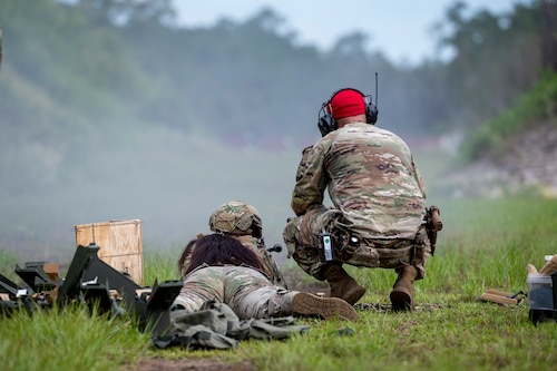 Airmen crouch on a rifle range
