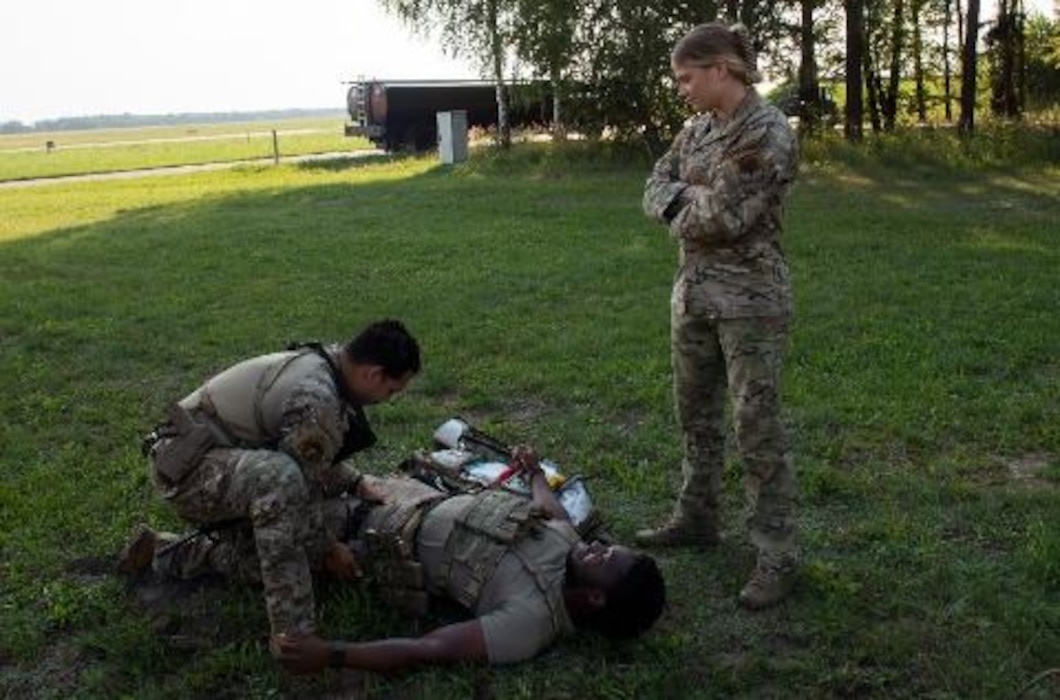 U.S. Air Force Tech. Sergeant Summers Teeters (right), 824th Base Defense Squadron Independent Duty Medical Technician, trains Tech. Sergeant Jamian Carrasquillo (left), 824th BDS Squad Leader, and Senior Airman Jordan-LaMont Adrian Brown, (left) 822nd BDS Fire Team Leader in tactical combat casualty care Aug. 16, 2022 at Łask Air Base, Poland. The 820th Base Defense Group is made up of many Air Force Specialty Codes that provide unique interoperability skill sets within the squadron. Members in the unit are trained by individuals in different AFSCs to help multiply the unit’s efforts during missions. (U.S. Air Force photo by Staff Sergeant Danielle Sukhlall)