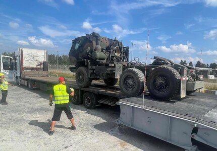 Contractors assigned to the 405th Army Field Support Brigade upload another Army Prepositioned Stocks-2 equipment piece onto a transport truck using the new Rapidly Available Interface for trans-Loading, or RAIL, modular ramp system. The Rail system is helping to expedite the movement of more than 5,000 APS-2 vehicles and equipment pieces. (Courtesy photo)