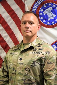 Soldier standing in front of flags