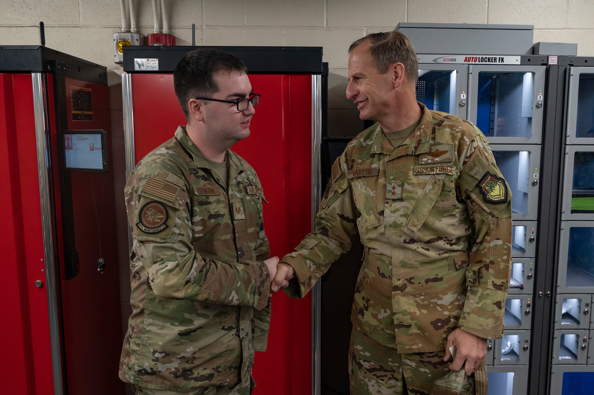 Maj. Gen. Corey Martin, 18th Air Force commander, coins Staff Sgt. Vincent Lohmann, C-130J Super Hercules crew chief, at Dyess Air Force Base, Texas, Aug. 25, 2022. Coinings are meant to recognize high-performing Airmen who excelled while supporting the air mobility mission. (U.S. Air Force photo by Senior Airman Josiah Brown)