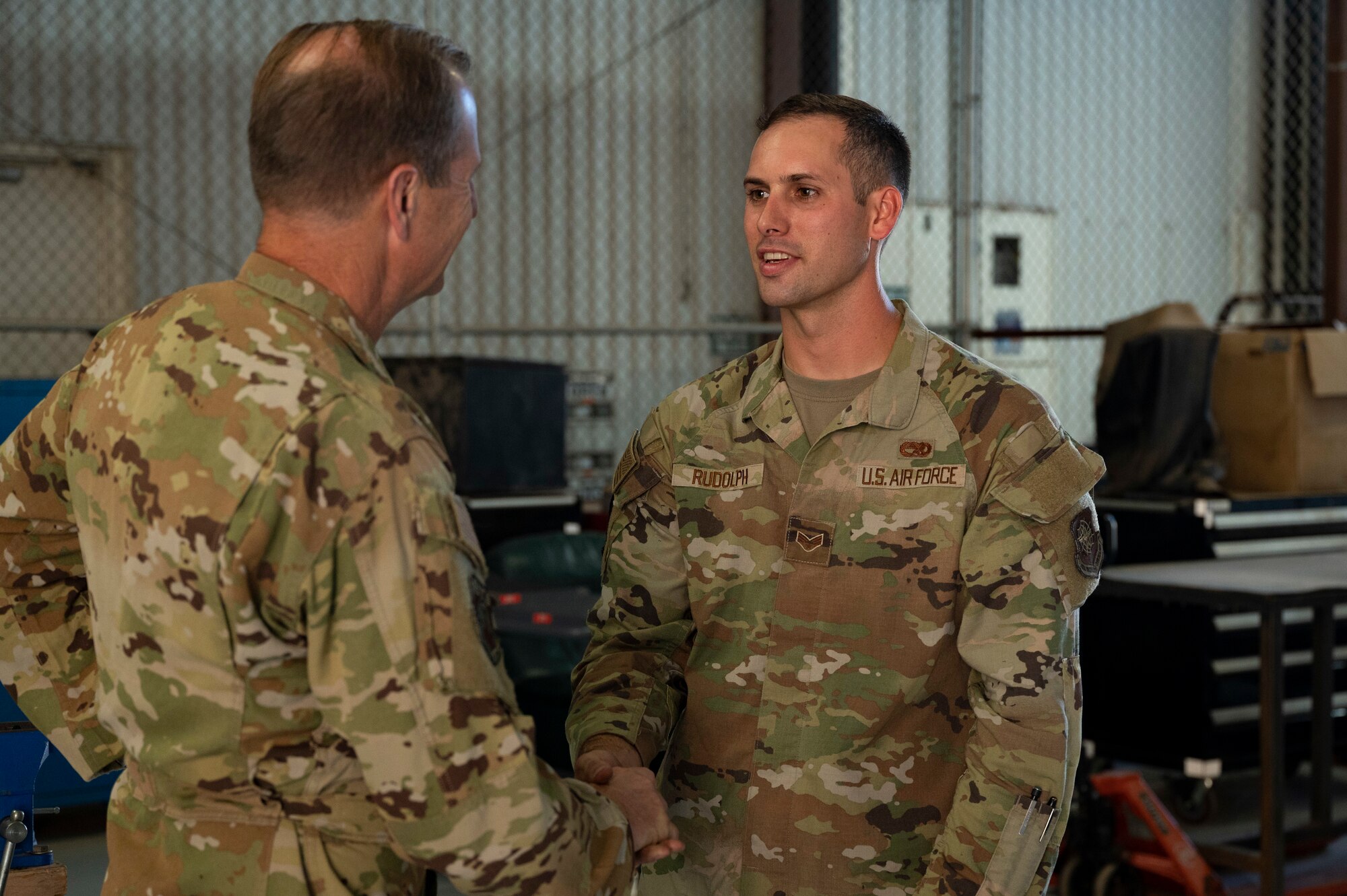Maj. Gen. Corey Martin, 18th Air Force commander, coins Senior Airman Cory Rudolph, 317th Maintenance Squadron aerospace maintenance apprentice, at Dyess Air Force Base, Texas, Aug. 25, 2022. Gen. Martin was briefed on recent developments within the Wing by 317th Airlift Wing Airmen. (U.S. Air Force photo by Senior Airman Josiah Brown)