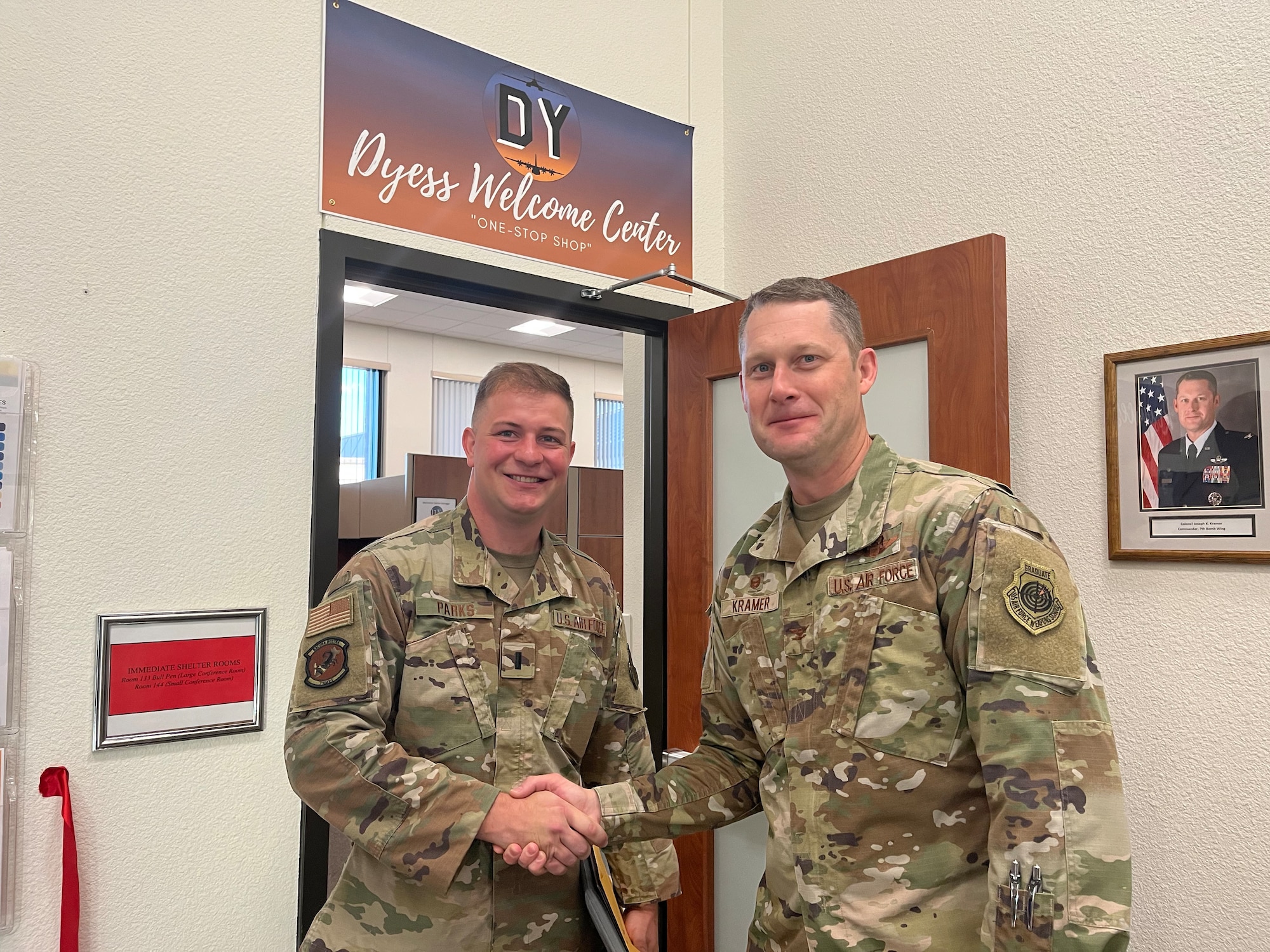 Col. Joseph Kramer, 7th Bomb Wing commander, right, shakes the hand of 1st Lt. Garrett Parks, 9th Aircraft Maintenance Unit officer in-charge, during the grand opening of the new Dyess Welcome Center at Dyess Air Force Base, Texas, Aug. 29, 2022. Parks was the first Airman to officially in-process at Dyess AFB using the new streamlined welcome center. (U.S. Air Force photo by Tech. Sgt. David Scott-Gaughan)