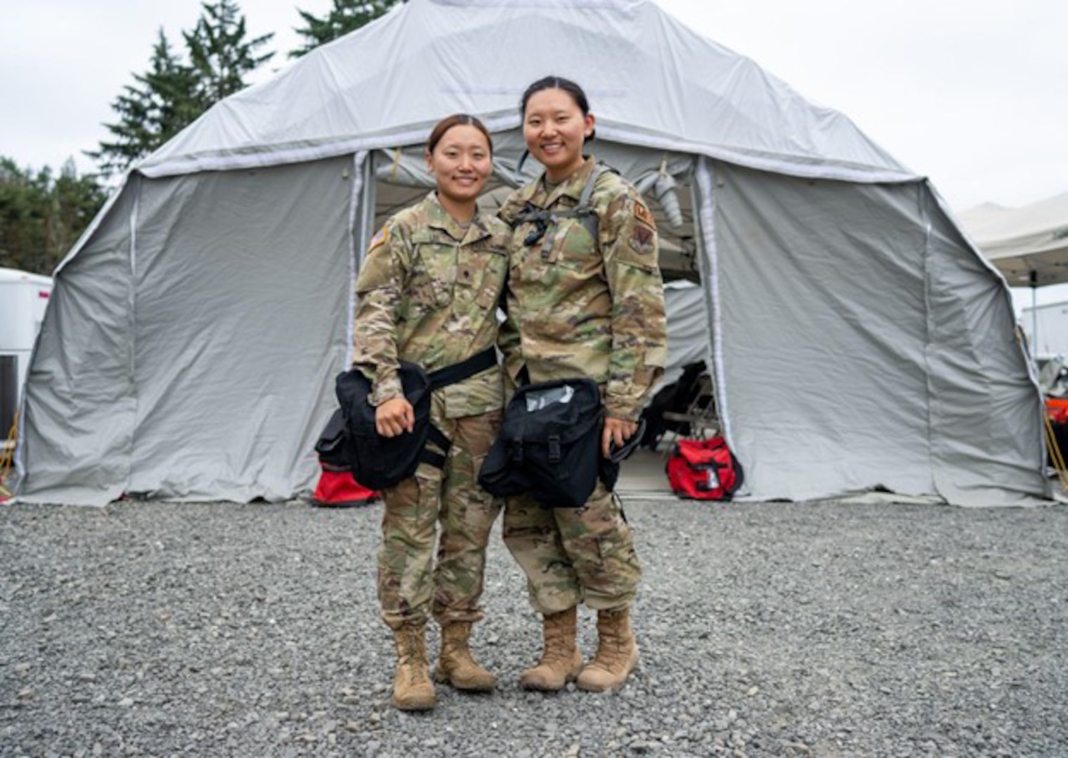 U.S. Army Spc. Jessica Lee, left, 928th Area Support Medical Company, Colorado Army National Guard, and U.S. Air Force Senior Airman Julie Lee, 140th Medical Group, Colorado Air National Guard ,participate in an external evaluation at Camp Rilea, Oregon, July 12, 2022. The sisters serve together in the Colorado National Guard’s Chemical, Biological, Radiological, Nuclear and high-yield explosive Enhanced Response Force Package.
