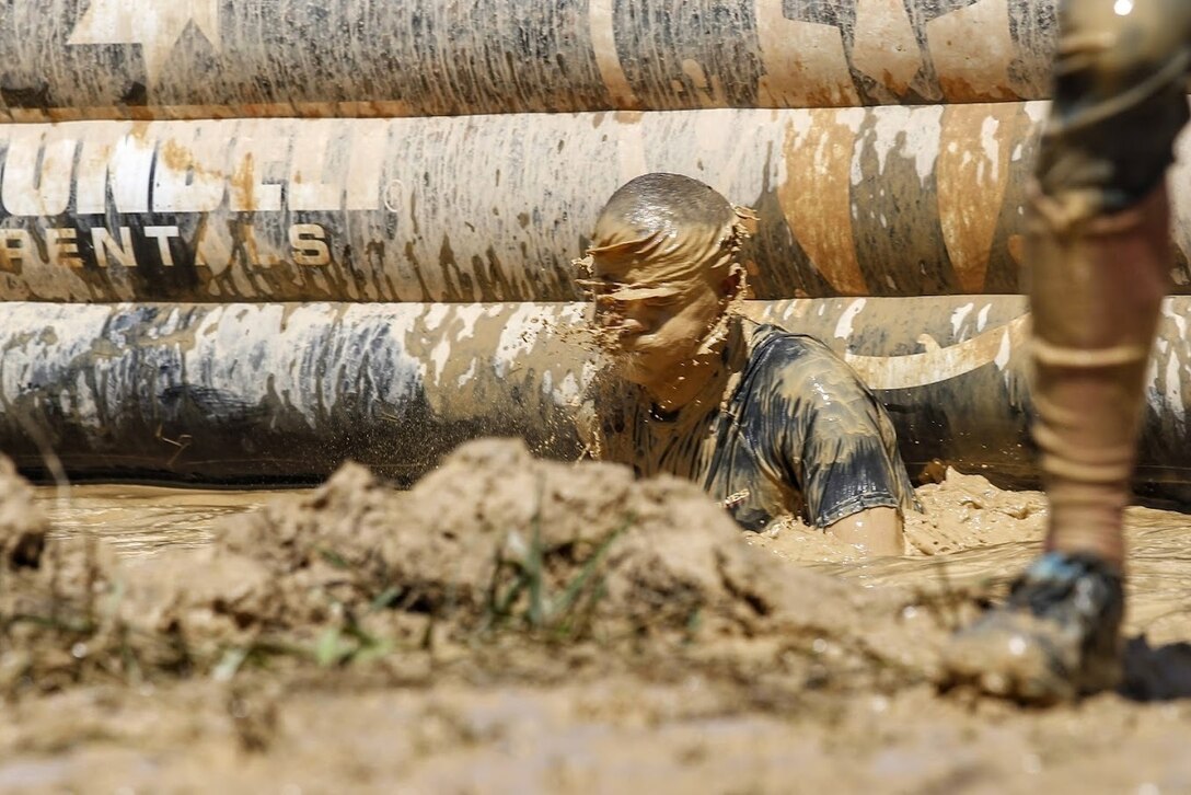 U.S. Marine Corps Master Sgt. Micheal Wood, a former member of the All-Marines Running Team, emerges from the "Dunk Wall" during the running of the Sprint 5K at the 2022 West Virginia Spartan Trifecta Weekend Event in Glen Jean, West Virginia, Aug. 28, 2022.  Marine Corps Recruiting Command has partnered with the Spartan Race and their community of Athletes during 2022 through National and local level event activations.