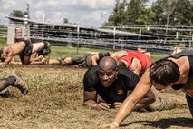U.S. Marine Corps Staff Sgt. Tyon Downing, force fitness instructor with Force Fitness Readiness Center of Excellence, Marine Corps Base Quantico, low crawls under barbwire during tat the Sprint 5K at the 2022 West Virginia Spartan Trifecta Weekend Event in Glen Jean, West Virginia, Aug. 28, 2022.  Marine Corps Recruiting Command has partnered with the Spartan Race and their community of Athletes during 2022 through National and local level event activations. The partnership celebrates athletes' discipline, fighting spirit, and will to overcome obstacles and complete the mission are values shared with the Corps. (U.S. Marine Corps photo by Lance Cpl. Gustavo Romero)