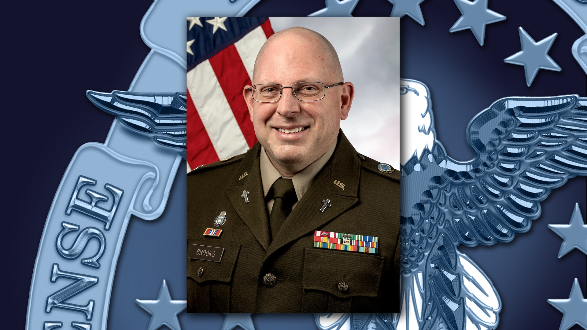 An Army Chaplain poses in front of the American flag.