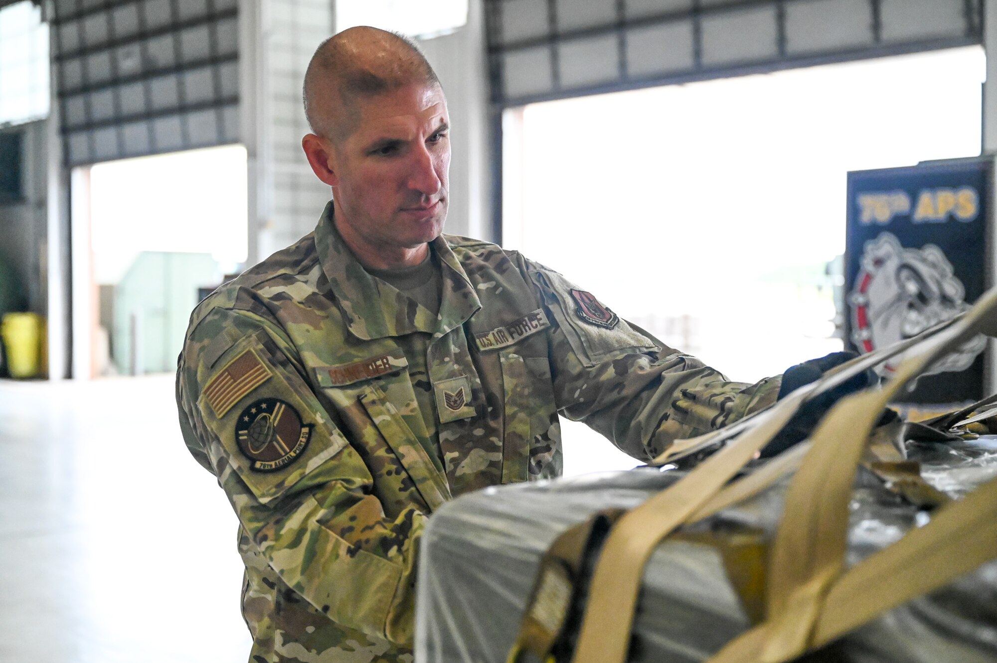 Tech. Sgt. Jason Schneider, a special handling representative with the 76th Aerial Port Squadron, tightens straps on a pallet, June 4, 2022, at Youngstown Air Reserve Station, Ohio.
