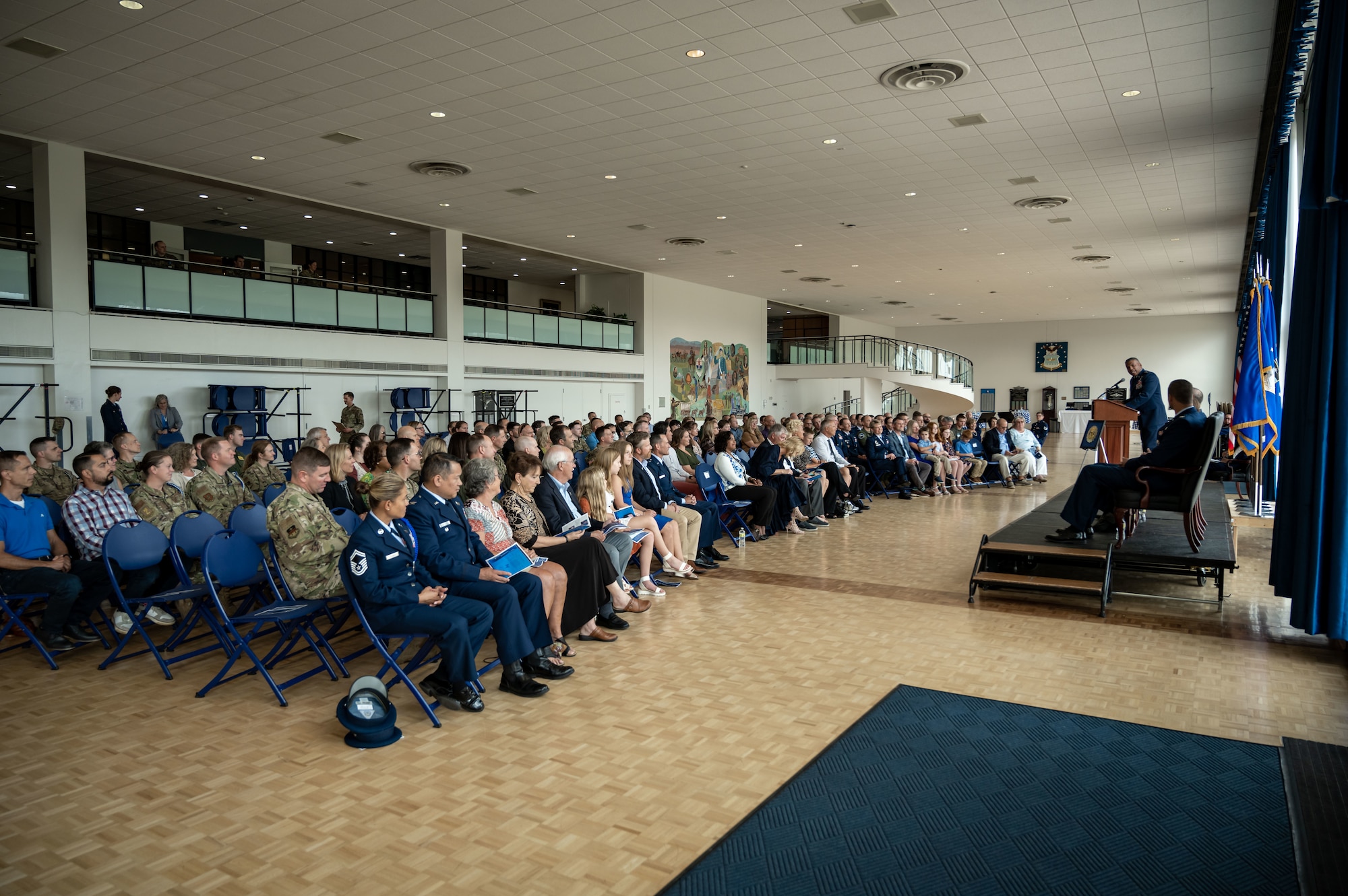 A crowd gathers in the Arnold Hall Ballroom at the U.S. Air Force Academy, Colorado, and listens to Lieutenant General Richard Clark, Academy superintendent deliver remarks during a Permanent Professor Investiture ceremony on August 19th 2022.