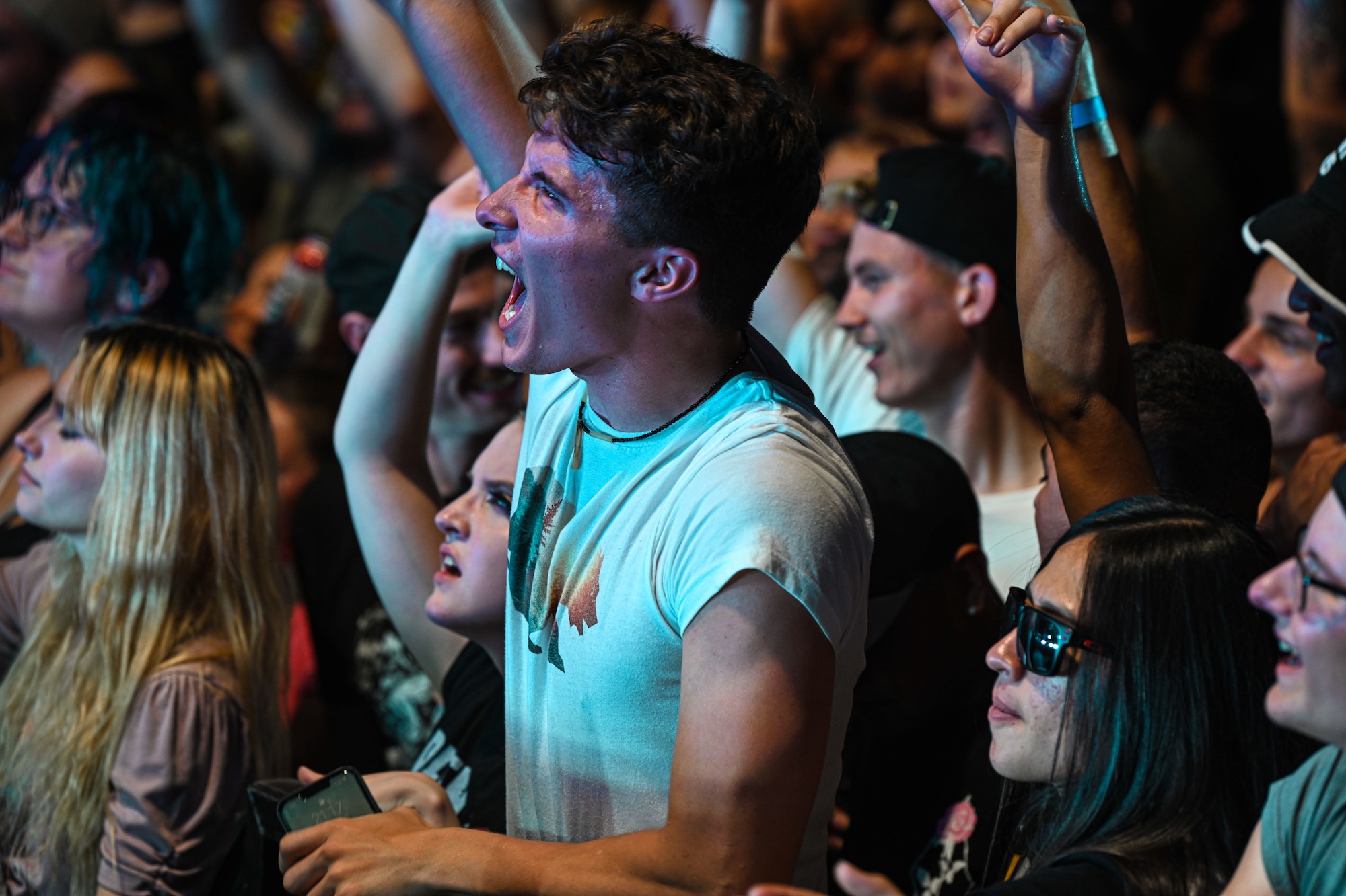 Airmen jump with energy at a concert.