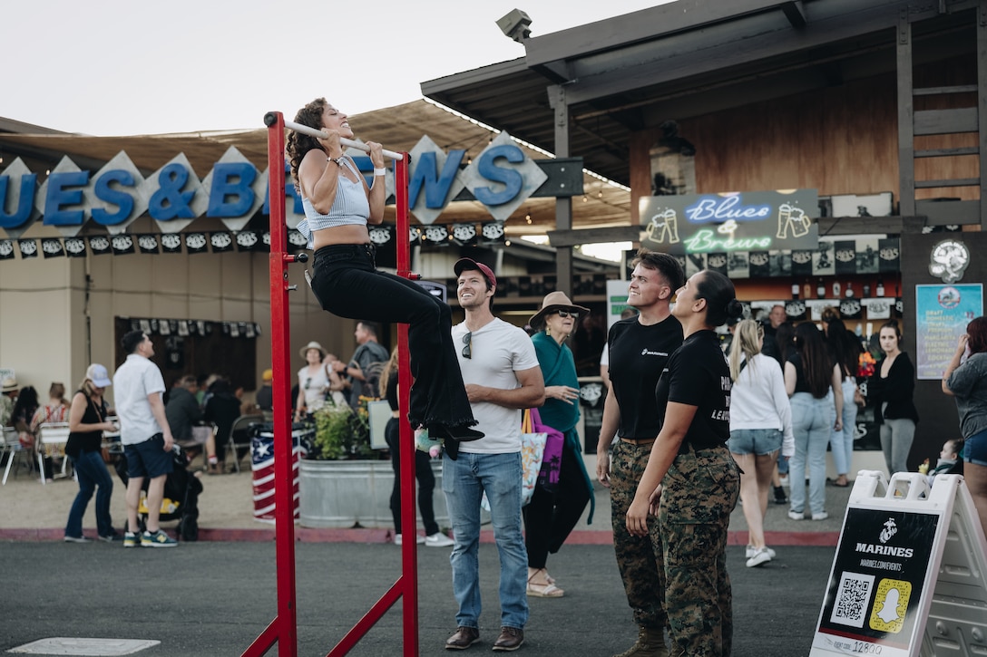 A fair attendee attempts pull-ups during a Marine Corps pull-up challenge at the Sonoma County Fair. The Marines of Recruiting Sub-Station Santa Rosa hosted a pull-up challenge and talked to fair attendees interested in learning more about the opportunities available within the Marine Corps.