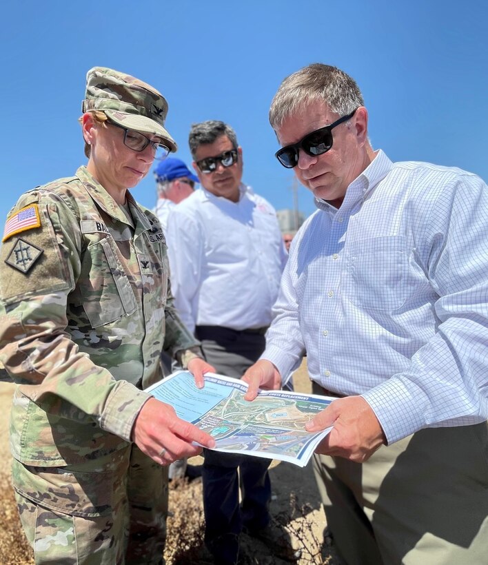 Col. Julie Balten, U.S. Army Corps of Engineers Los Angeles District commander, left, shows a map of modifications for Prado Dam to Al Lee, director of civil works for the U.S. Army Corps of Engineers, right, during a tour of dam Aug. 23 in Corona, California. Between Balten and Lee is John Moreno, the Corps’ South Pacific Division programs director.