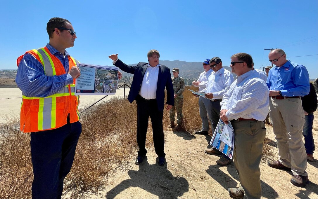 Bill Empson, Senior Dam and Levee Safety risk advisor with the U.S. Army Corps of Engineers’ Institute for Water Resources, center, provides updates to Al Lee, director of civil works for the U.S. Army Corps of Engineers, second from right, during a tour of Prado Dam Aug. 23 in Corona, California.