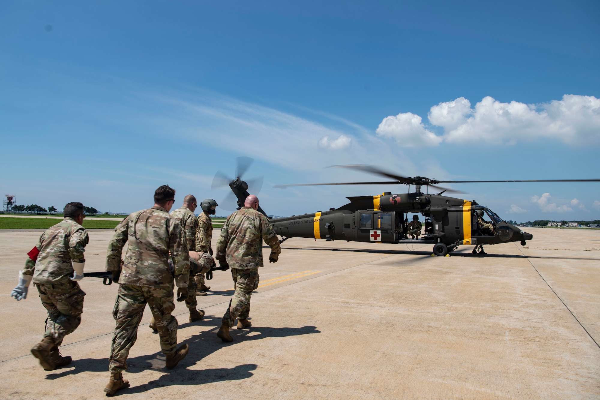 Airmen with the 8th Medical Group perform a litter carry to a UH-60 Black Hawk during a training event at Kunsan Air Base, Republic of Korea, Aug. 18, 2022. The 8th MDG is devoted to optimizing the installation’s readiness in preparation of follow-on forces. (U.S. Air Force photo by Staff Sgt. Sadie Colbert)