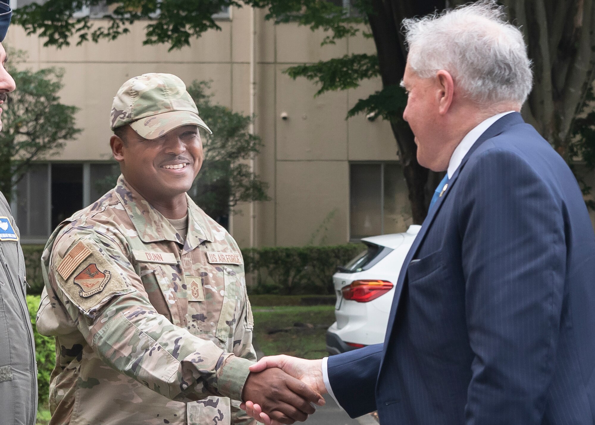 Chief Master Sgt. Jerry Dunn, 374th Airlift Wing command chief, left, greets Secretary of the Air Force Frank Kendall during his visit to 374th Airlift Wing headquarters at Yokota Air Base, Japan, Aug. 24, 2022.
