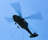 Soldiers from the 28th Expeditionary Combat Aviation Brigade hold the UH-60 Black Hawk steady as Soldiers from the Headquarters and Headquarters Company, 1st Battalion, 110th Infantry Regiment, 2nd Infantry Brigade Combat Team, rappel down during training at Fort Indiantown Gap, Pa., Aug. 3, 2022. The rappel training was practice and preparation for the Soldiers to rappel from the Black Hawk onto a building.