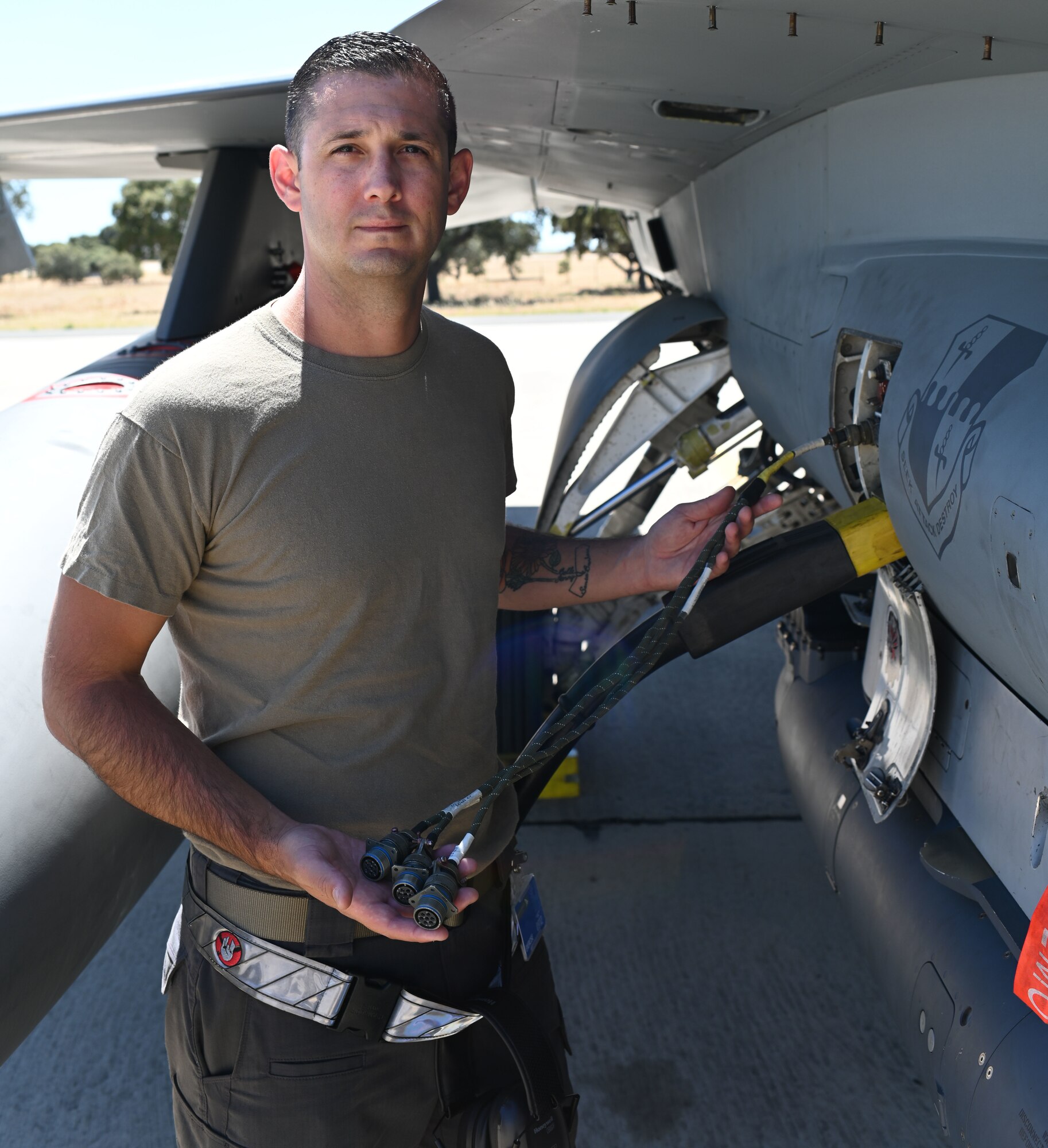 Airman holding a cable at a jet