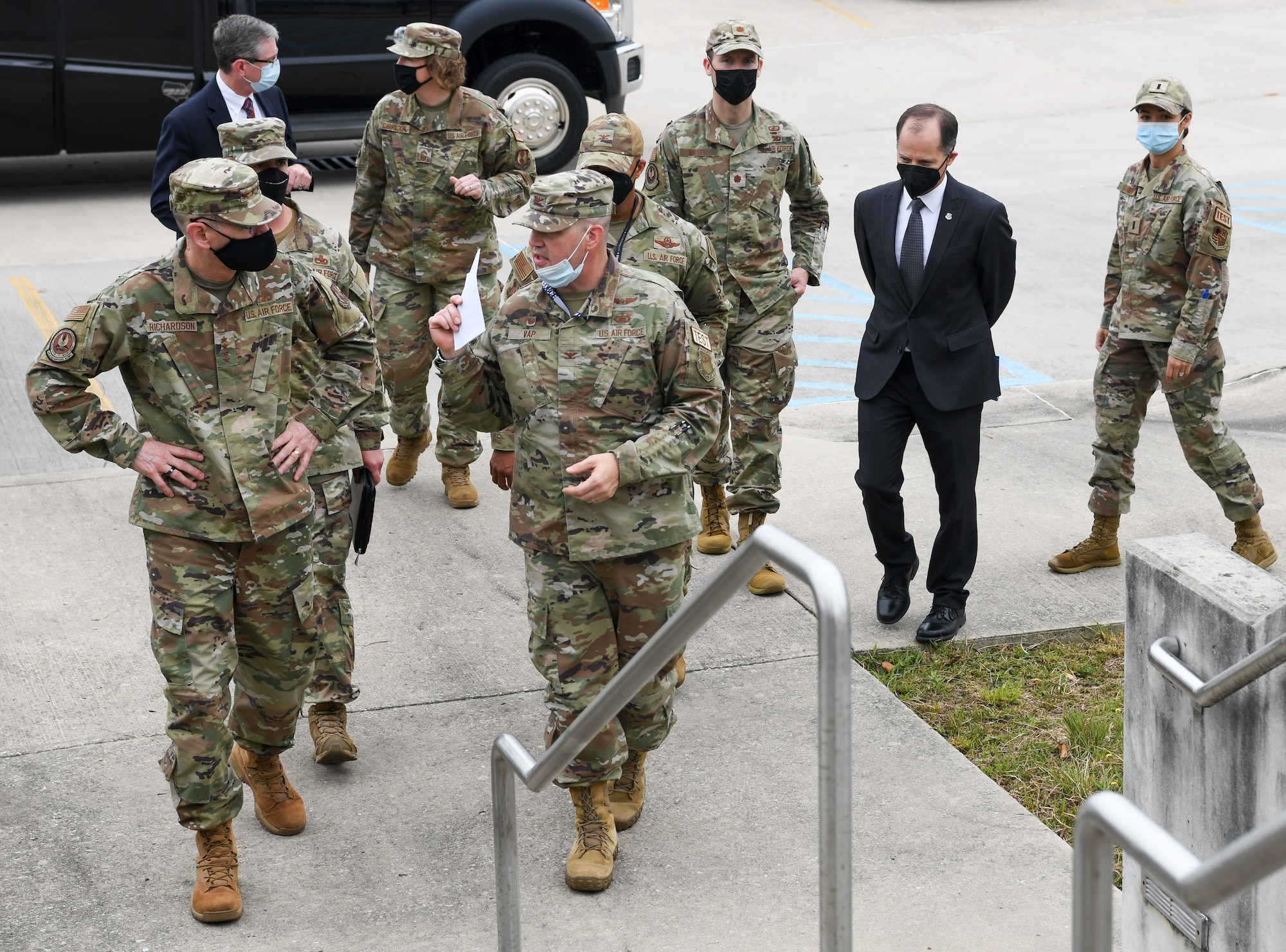 Group of uniformed military and civilian Airmen walking in group