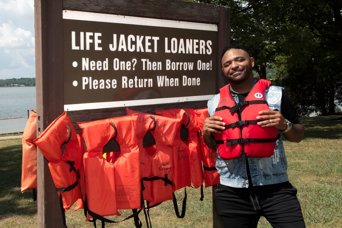 The Artist Muneer Gonsalves poses by the Life Jacket Loaner Board at J. Percy Priest Lake’s Cook Recreation Area in Hermitage, Tennessee, Aug. 26, 2022, while partnering with the U.S. Army Corps of Engineers to promote water safety. He encouraged Corps Lakes visitors to wear life jackets, make good decisions, and keep a close eye on children. (USACE Photo by Lee Roberts)