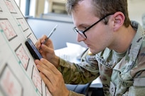 Pvt. 1st Class Samuel Schmelzer, 376th Financial Management Support Unit financial management technician, outlines exercise injects during exercise Diamond Saber at Joint Base McGuire-Dix, New Jersey, Aug. 12, 2022. Established in 2004, Diamond Saber is a U.S. Army Reserve-led exercise that trains and evaluates Soldiers and joint partners on warfighting functions such as funding the force, payment support, disbursing operations, accounting, fiscal stewardship, auditability and data analytics. (U.S. Army photo by Mark R. W. Orders-Woempner)