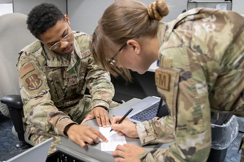 U.S. Air Force Reserve Senior Airman Paul Brawner, 914th Air Refueling Wing financial management technician, and Tech. Sgt. Marissa Rustici, 439th Airlift Wing financial management technician, exercise check-cashing operations during exercise Diamond Saber at Joint Base McGuire-Dix, New Jersey, Aug. 14, 2022. Established in 2004, Diamond Saber is a U.S. Army Reserve-led exercise that trains and evaluates Soldiers and joint partners on warfighting functions such as funding the force, payment support, disbursing operations, accounting, fiscal stewardship, auditability and data analytics. (U.S. Army photo by Mark R. W. Orders-Woempner)