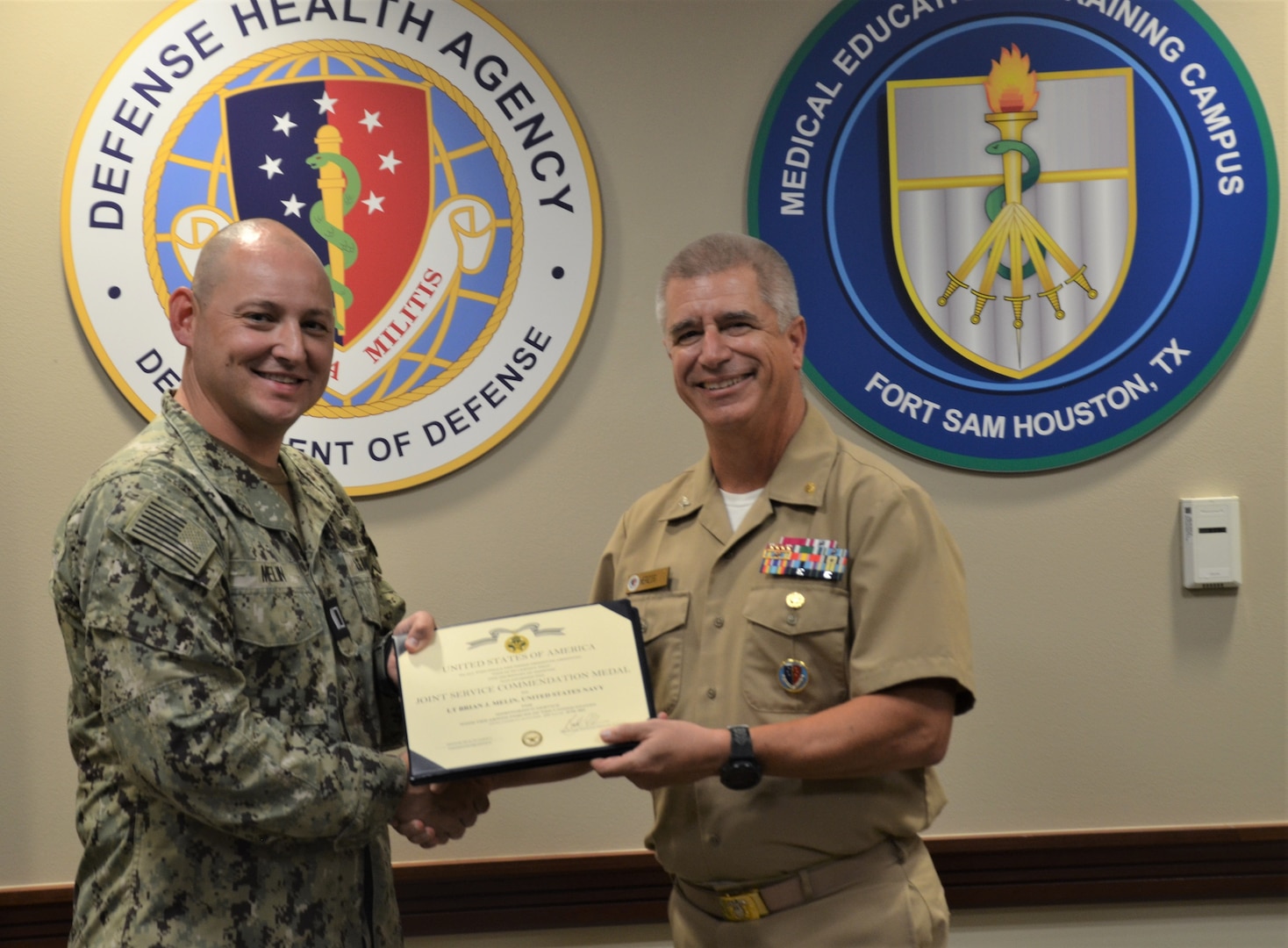 Navy Lt. Brian Melin, Navy Service Lead in the joint Army/Navy Medical Laboratory Technician program at the Medical Education and Training Campus, took immediate action when he spotted a referee at his daughter's volleyball tournament on the ground and unresponsive with no pulse. Melin performed cardiopulmonary resuscitation for approximately ten minutes until the referee regained a heartbeat. For his selfless, lifesaving actions, Melin was awarded the Joint Service Commendation Medal presented to him by Navy Capt. Thomas Herzig, former METC Commandant.