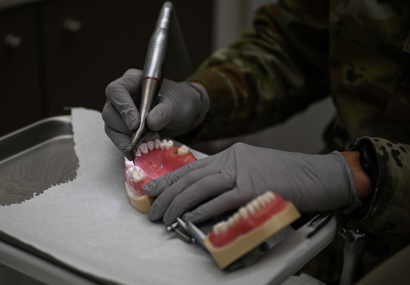 Dental resident uses dental drill on denture mold at JBLE.