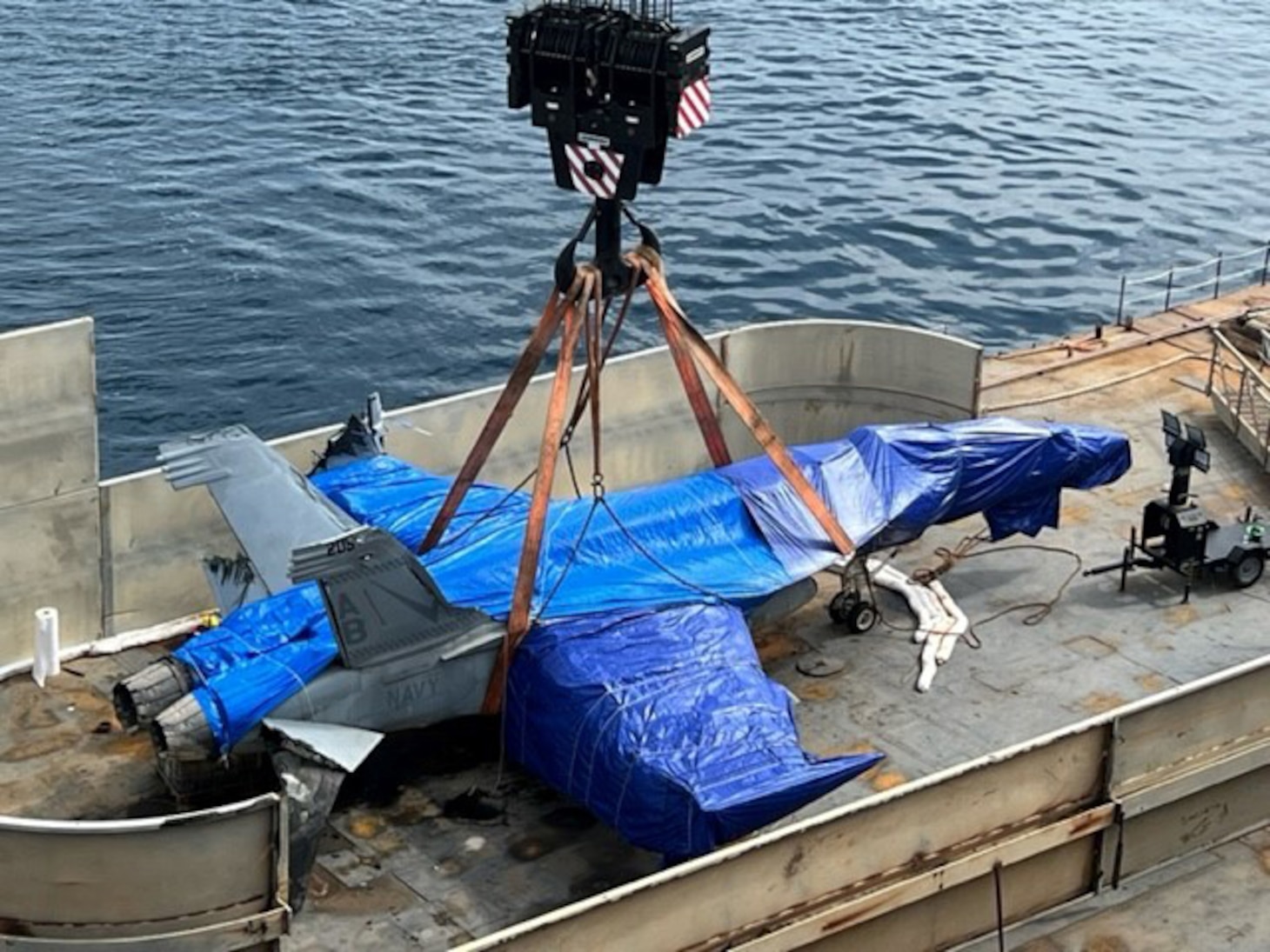 view of an F/A-18E Super Horner being lowered onto Military Sealift Command's large medium speed roll-on, roll-off ship USNS Mendonca (T-AKR 303) in Sicily, Italy, Aug. 16.