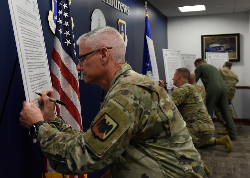 Maj. Gen. Keith MacDonald, Air National Guard Readiness Center commander, along with other JBA leadership, signs the Suicide Prevention Month proclamation, at Joint Base Andrews, Md., Aug. 31, 2022. September is designated as Suicide Prevention Month, a time when the Department of Defense brings added attention to the complex issue of suicide and emphasizes the valuable resources and support available year-round for active duty service members and their families, veterans, retirees and DoD civilians. (U.S. Air Force photo by Airman 1st Class Austin Pate)