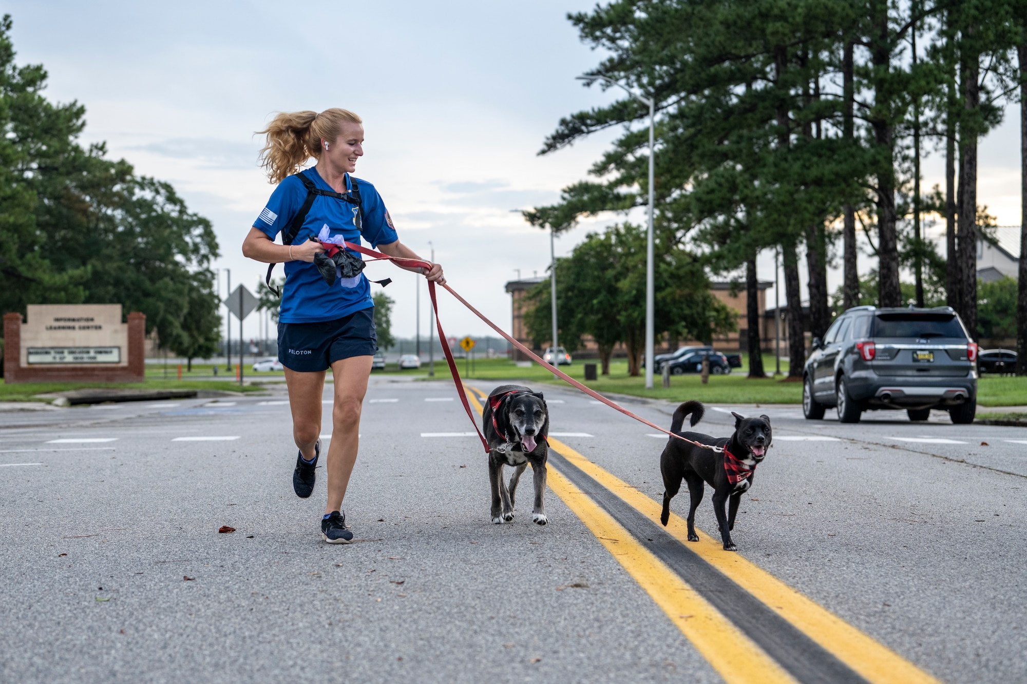 Airman runs with her dogs