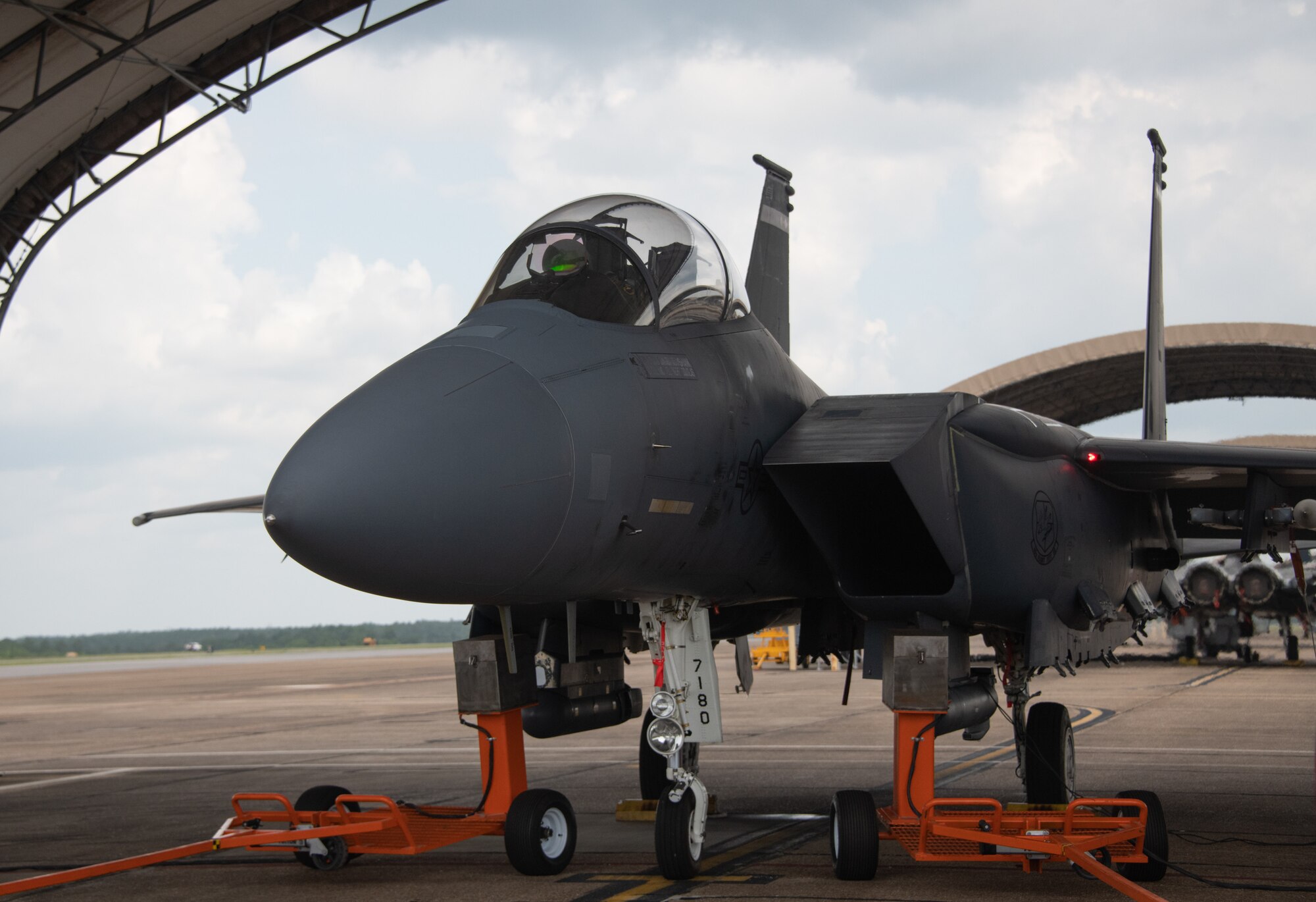 Analysts from the Air Force Research Laboratory's 711th Human Performance Wing use the orange spray carts displayed to insert oil of wintergreen into the idling F-15E Strike Eagle prior to taxi at Eglin Air Force Base, Fla., Aug. 16, 2022. This test is part of a larger Department of Defense effort to evaluate cockpit environmental conditions after a chemical weapon attack (U.S. Air Force photo by Ilka Cole)